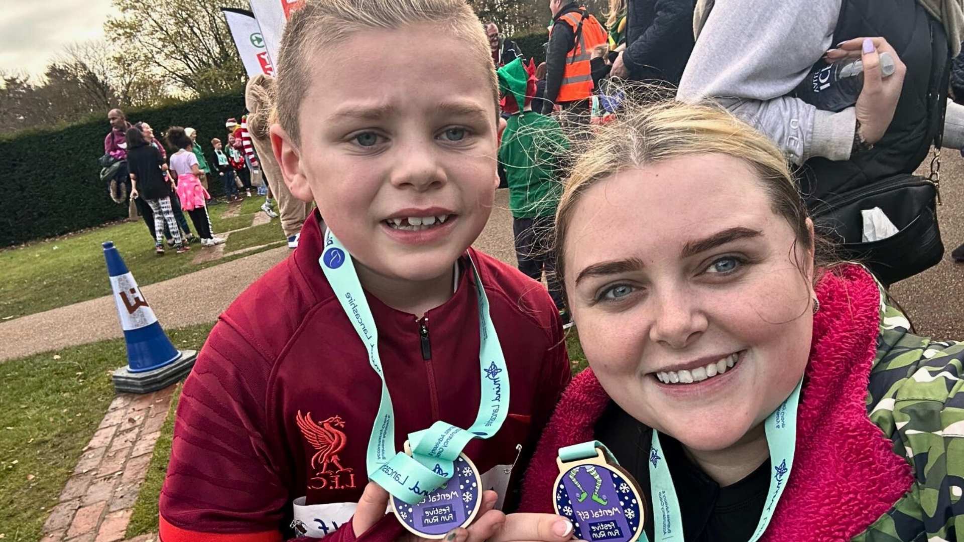Chloe and her son after the Mental Elf Lancashire fun run, standing proud with their medals in Worden Park at the finish line