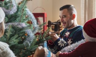Working family decorating their Christmas tree with a small child
