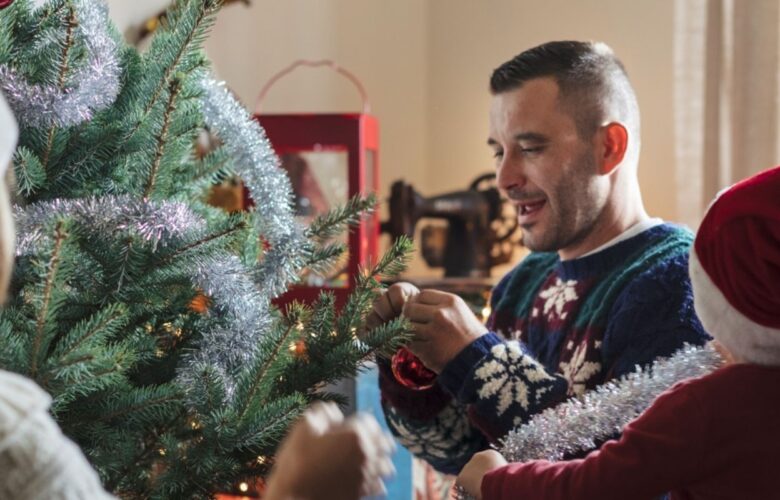 Working family decorating their Christmas tree with a small child