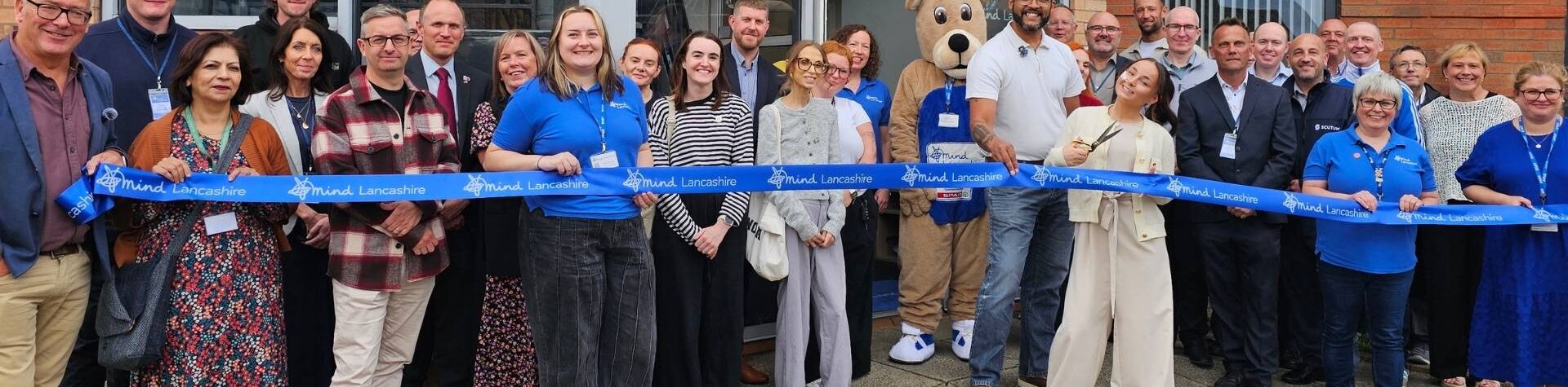 Lancashire Mind opens new office in Leyland, ribbon cutting with staff, guests and Clarke Carlise